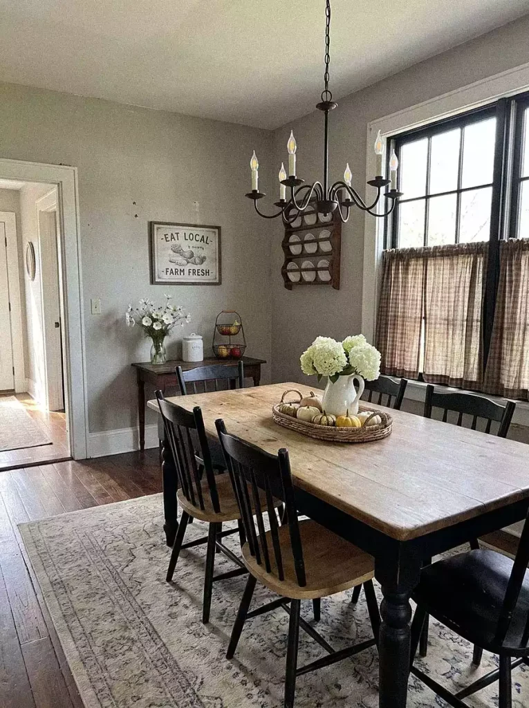 A country sign and wall mounted plate rack create cozy Dining Wall Decor above a rustic table with white hydrangeas