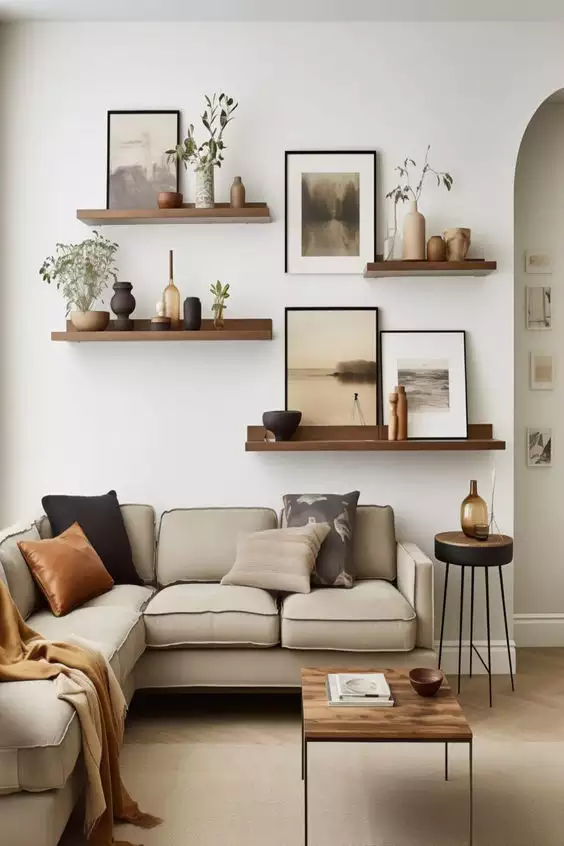 Beige sectional beneath walnut shelves and art on the above sofa wall