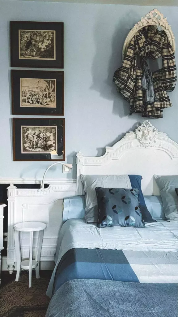 Black Framed Gallery Wall Decor With A Robe Hook Beside The Bed