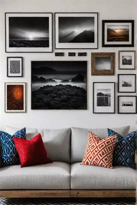 Black-and-white photography gallery wall above gray sofa in living room