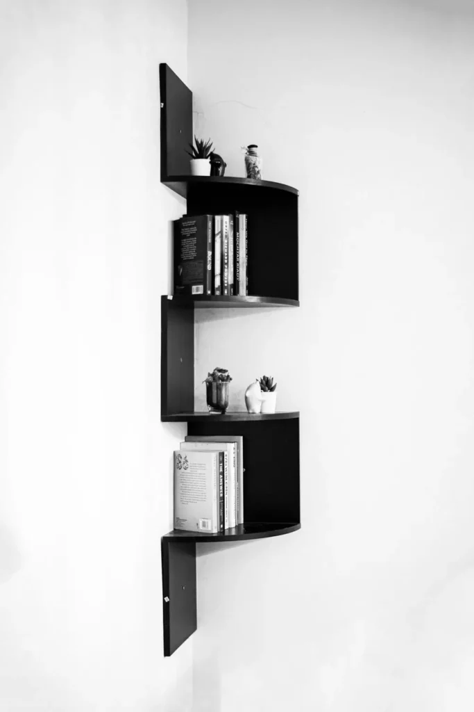 Black curved Corner Wall Decor with floating shelves, books and succulents in modern white corner