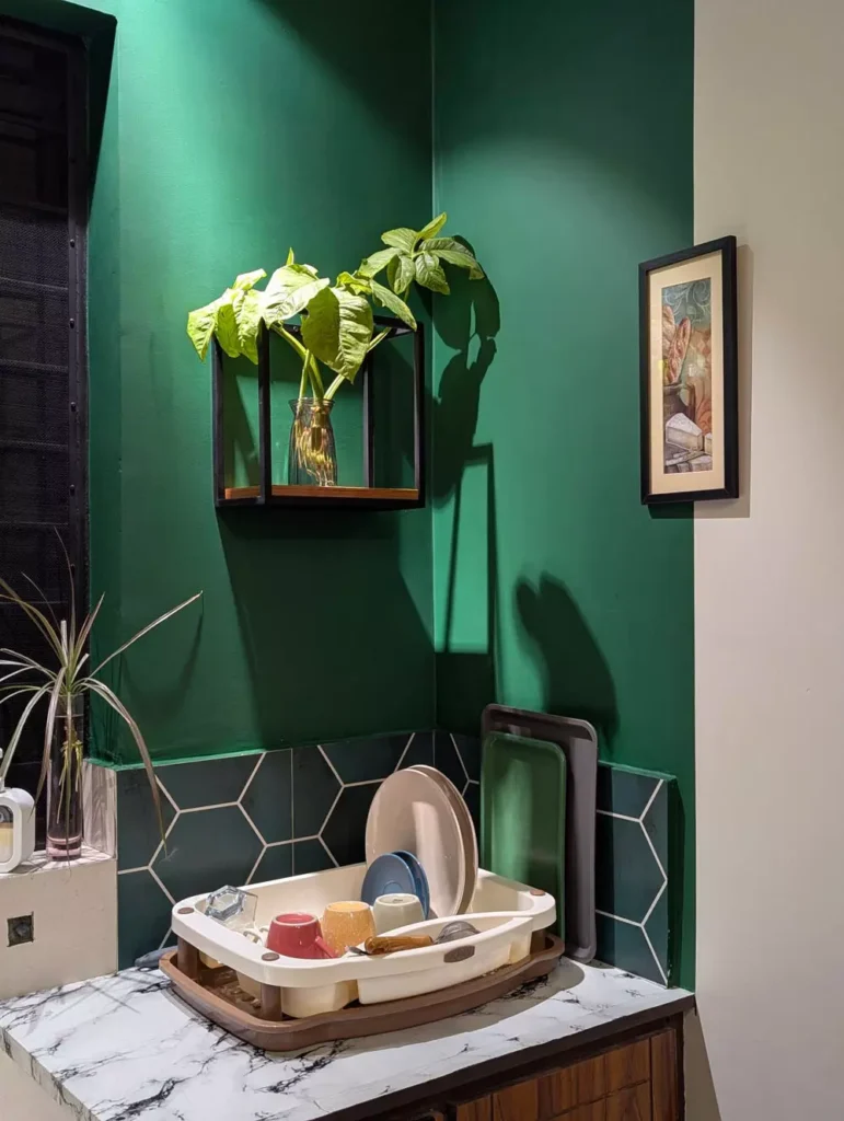 Black metal Corner Wall Decor with glass vase and pothos plant on emerald green kitchen corner