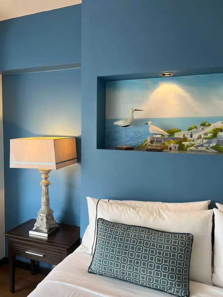  Blue Small Bedroom Wall Decor With A Lit Seascape Niche Above A Bedside Lamp