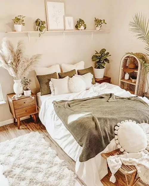 Boho bedroom with a floating shelf of framed art and potted plants as over the bed wall decor