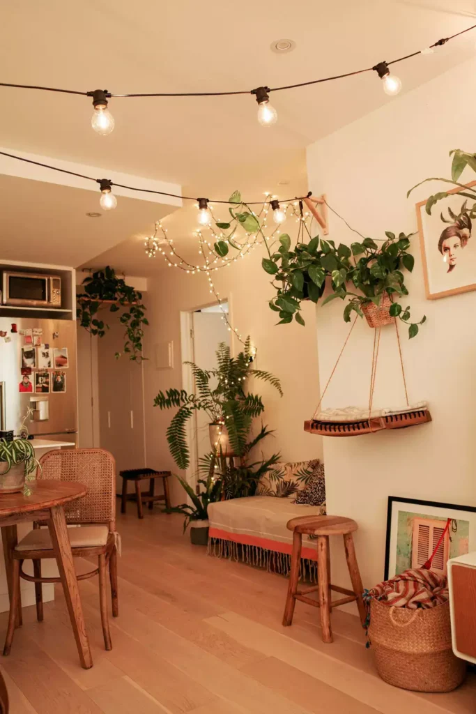 Boho living room decor with string lights, indoor plants and woven pouf seating