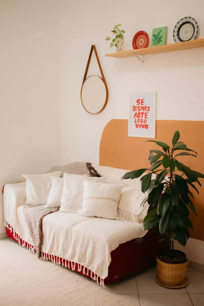 Boho tan wall living room daybed styled with white cushions beneath a mustard arch accent