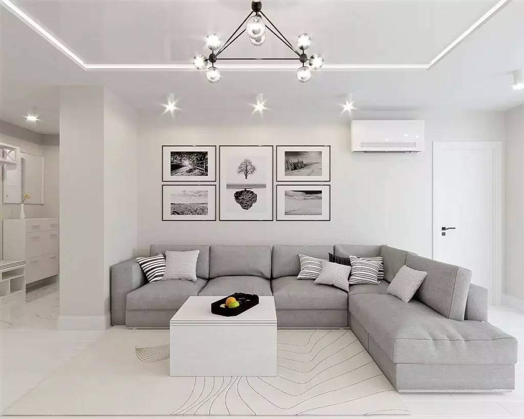 Bright white and grey living room idea with L shaped sofa and black and white gallery wall