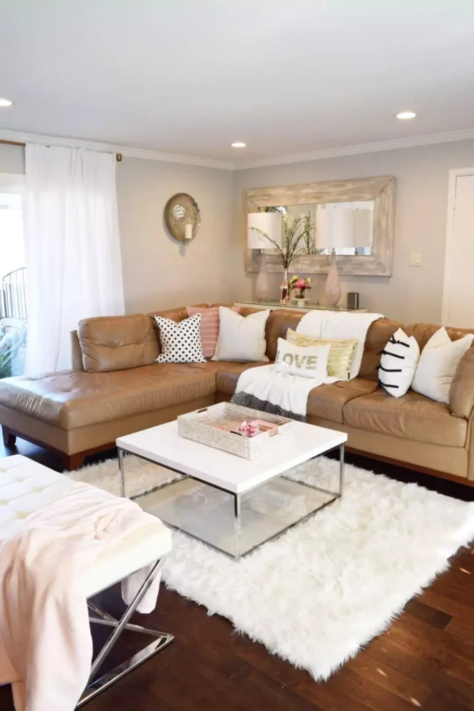 Camel leather sectional facing an oversized mirror on the above sofa wall