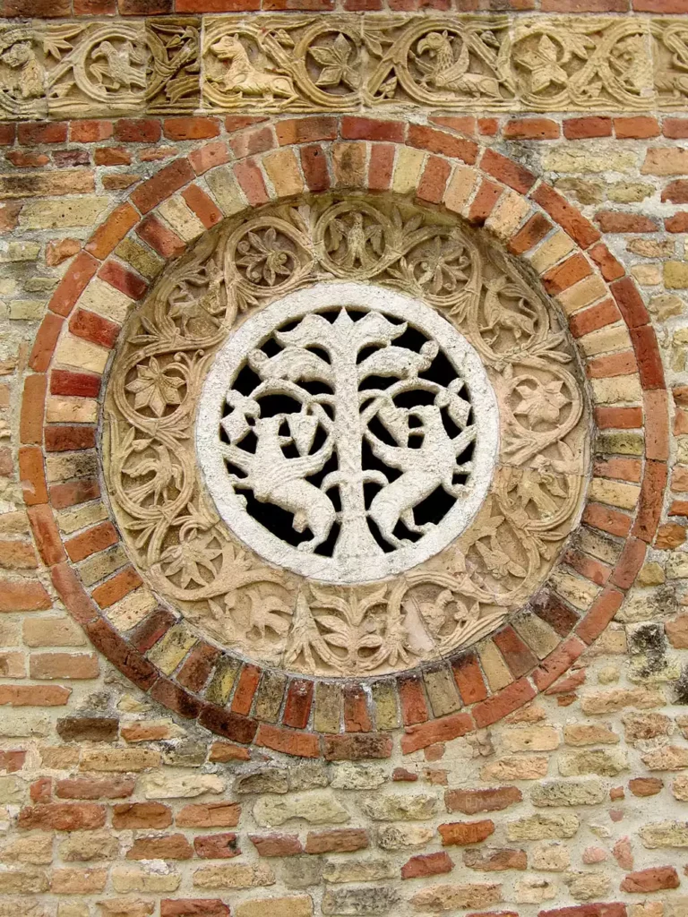 Carved Stone Rose Window Set Into An Outdoor Brick Wall