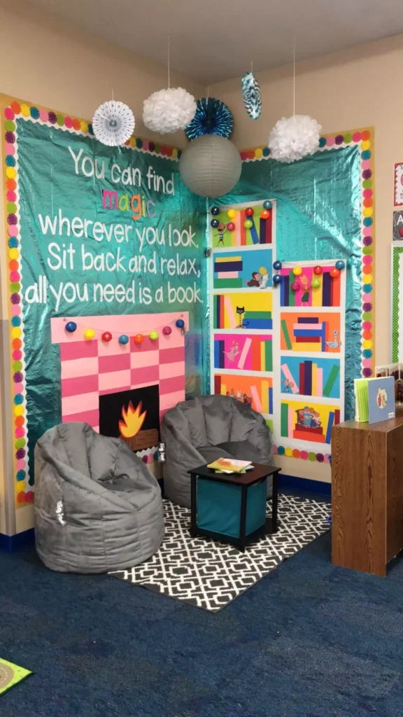 Classroom Reading Corner With A Faux Fireplace Mural Bookshelf Wall Decor And Gray Bean Bag Chairs