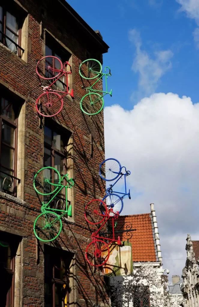Colorful Bicycles Mounted On The Facade Of A Brick Wall Building