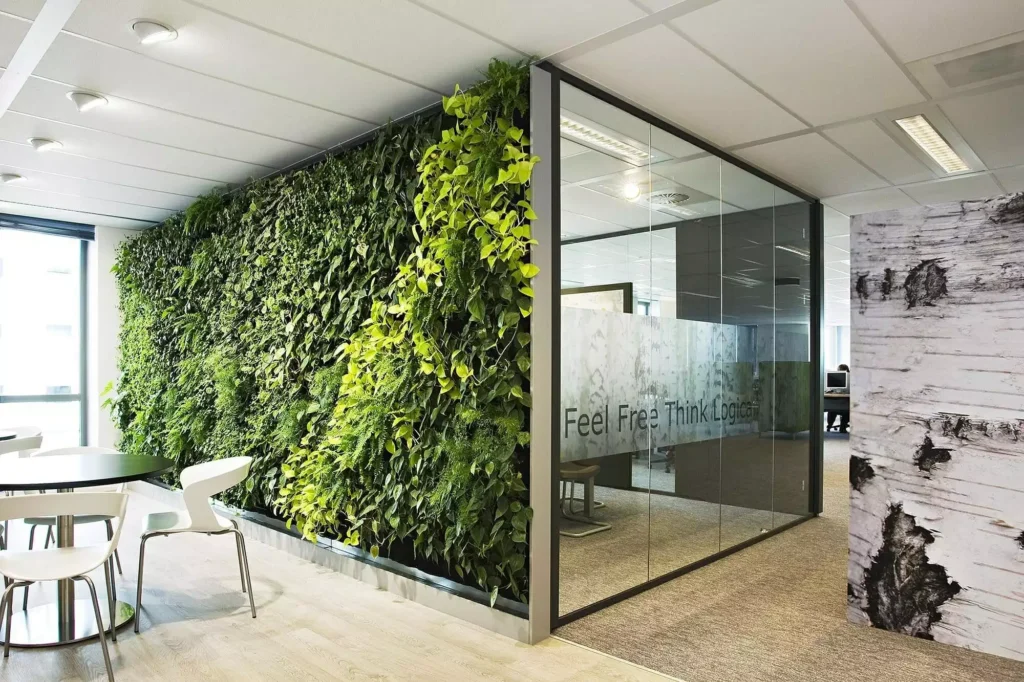 Contemporary office with a living green wall beside a glass meeting room