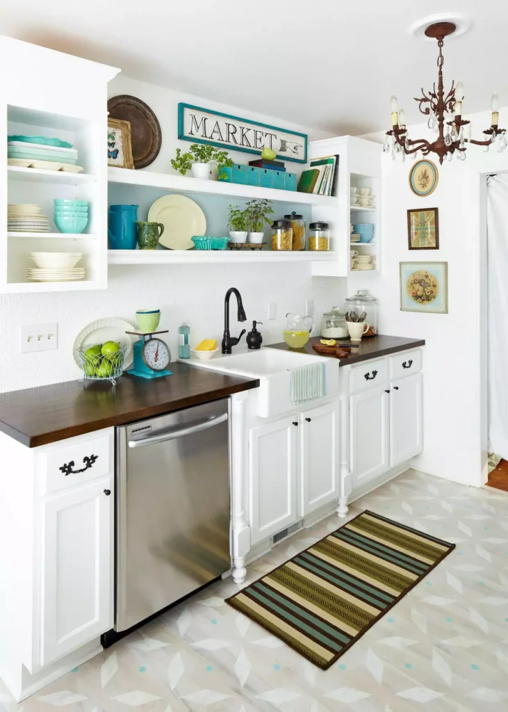 Cottage kitchen wall with a MARKET sign, open shelves, and stacked turquoise dishes