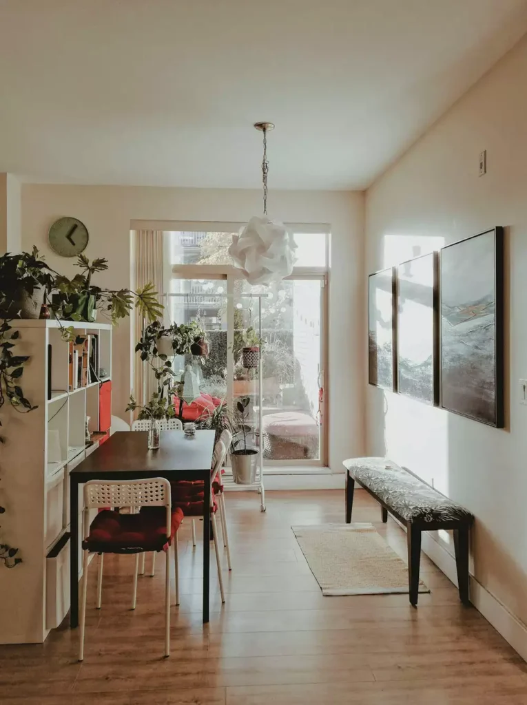 Cozy dining nook room decor with wooden table, hanging plants and vintage wall clock