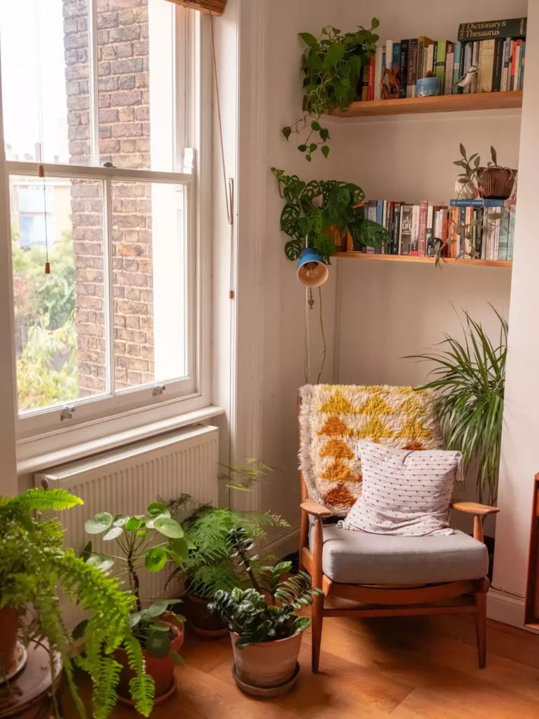 Cozy reading nook Corner Wall Decor with wooden bookshelves, hanging plants and mid-century chair by window