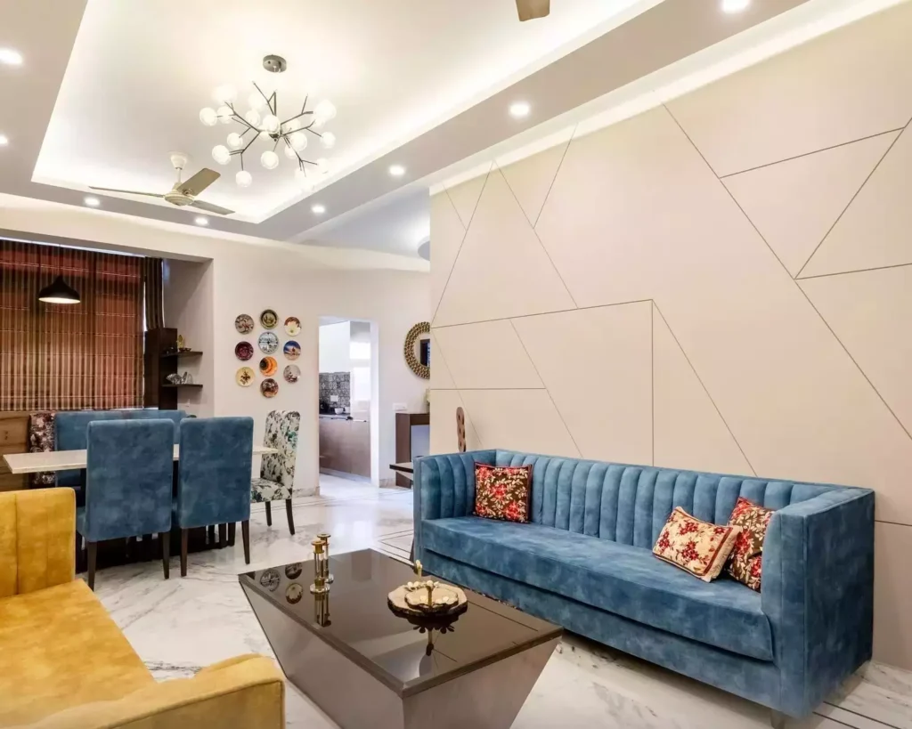 Cream geometric white wall, channel-tufted blue sofa, marble floor, globe light