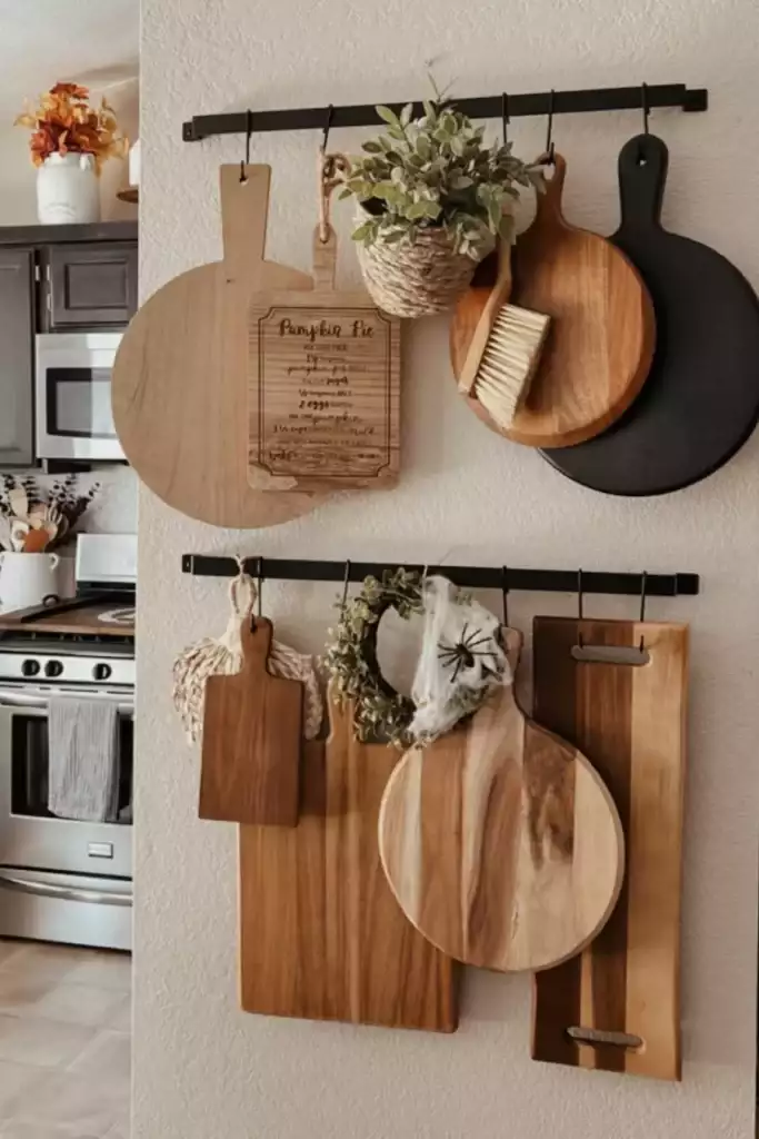 Cutting boards hanging from two black rails on a kitchen wall