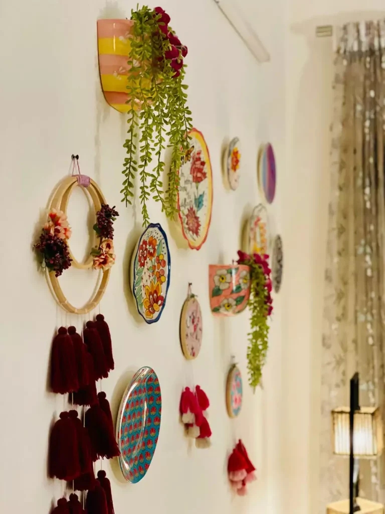 DIY corner wall decor with colorful decorative plates and burgundy tassel wall hanging with trailing plants