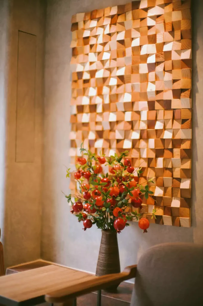 DIY corner wall decor with custom 3D wooden block mosaic wall art and modern pomegranate vase on table