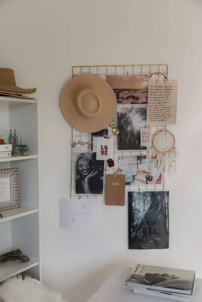 DIY corner wall decor with gold metal grid mood board displaying photos and hat with dreamcatcher and plants