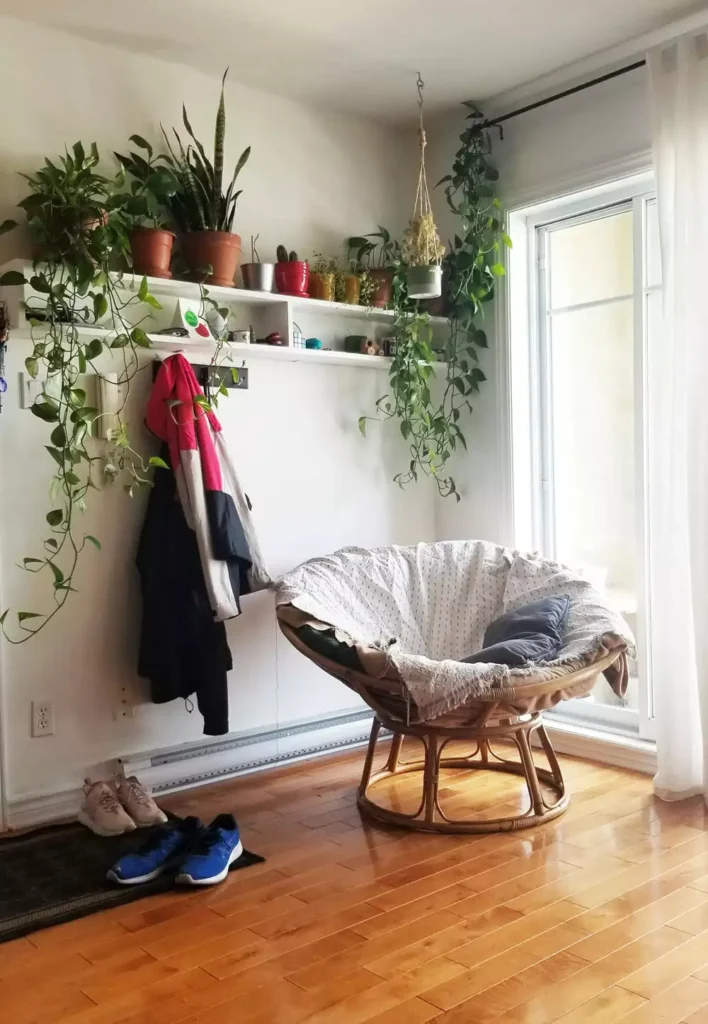 DIY corner wall decor with papasan chair and floating shelf styled with plants and woven baskets in entryway corner