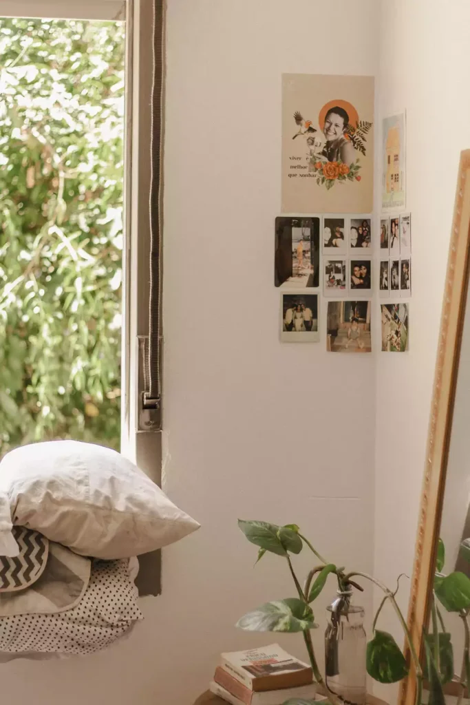 DIY corner wall decor with photo collage wall and cozy window seat with striped pillows and bottle plants