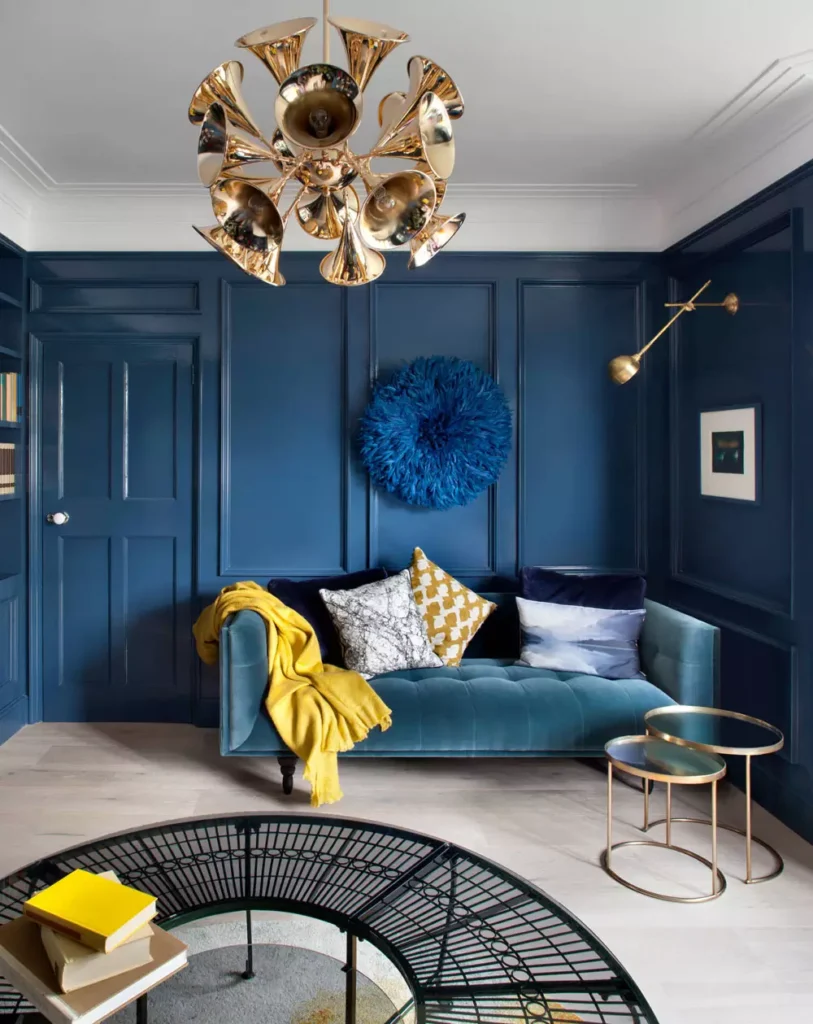 Dark Blue Paneled Living Room With A Brass Starburst Chandelier
