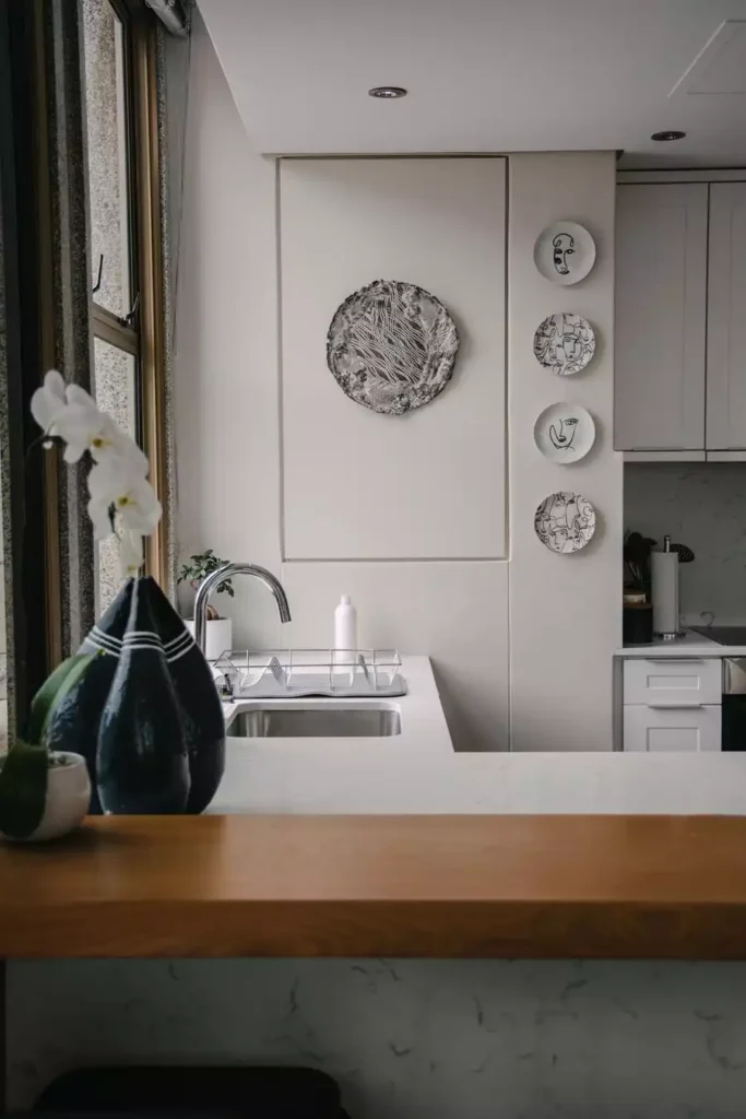 Decorative Plates Arranged On A White Wall Add Modern Kitchen Wall Decor Beside An Open Counter