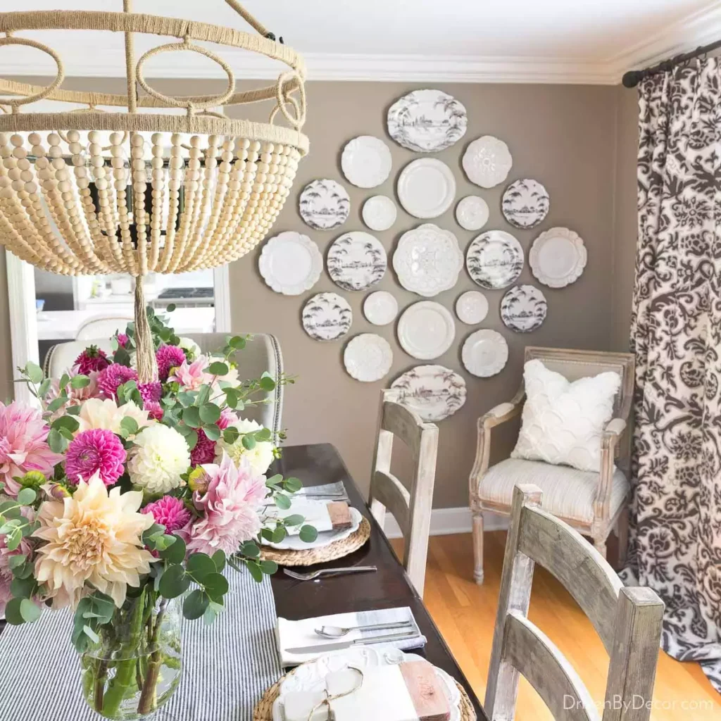 Decorative vintage plate wall arranged in a diamond above dining chairs