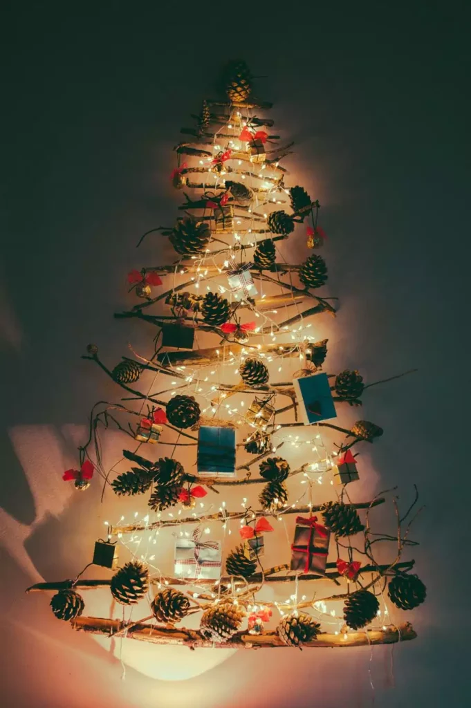 Driftwood Branch Christmas Wall Tree Glowing With Fairy Lights And Pinecones In A Dark Room