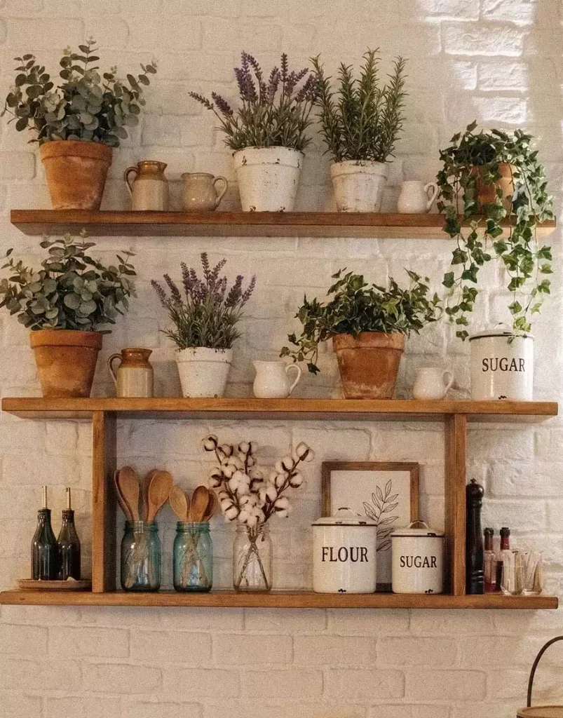 Farmhouse Wall Shelving Lined With Terracotta Herb Pots, Enamel Sugar And Flour Canisters, And Mason Jars Of Wooden Spoons Above A White Brick Backdrop (new replacement image)