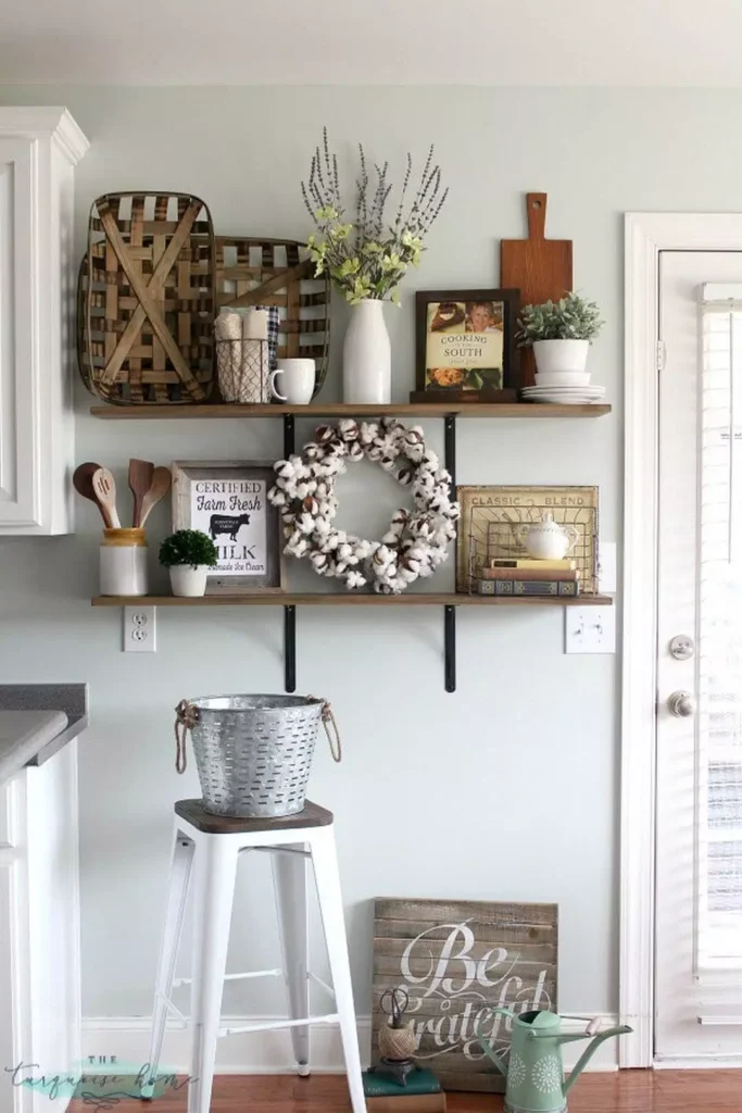 Farmhouse kitchen wall with two wood shelves, baskets, and a cotton wreath