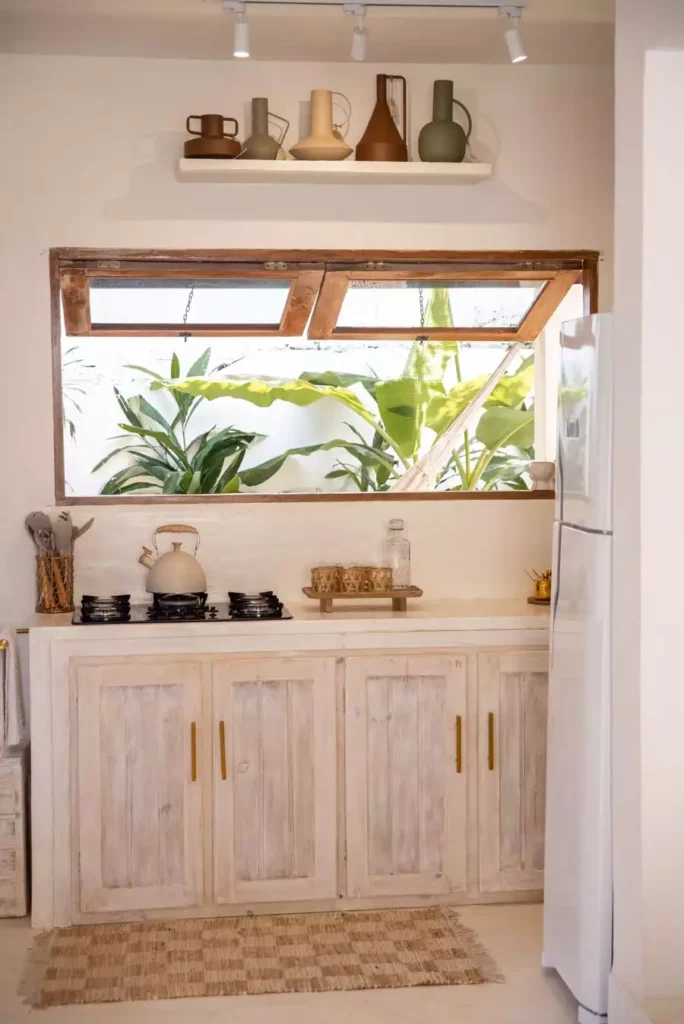 Floating Shelf With Ceramic Vases Above A Window Adds Earthy Kitchen Wall Decor