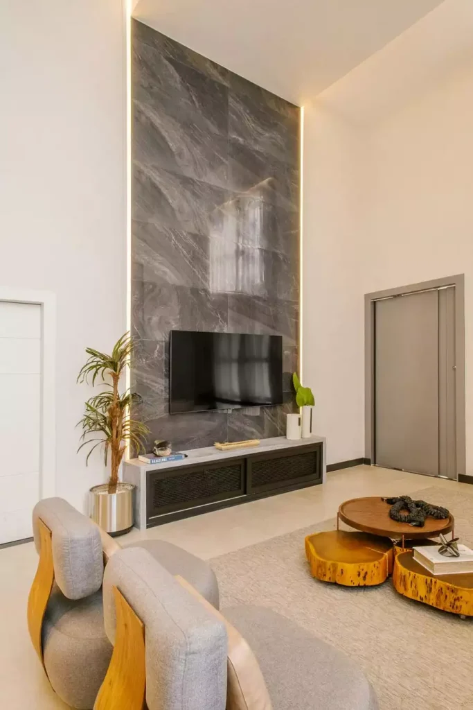 Floor To Ceiling Grey Marble TV Wall With Backlit Edges And Live Edge Coffee Table
