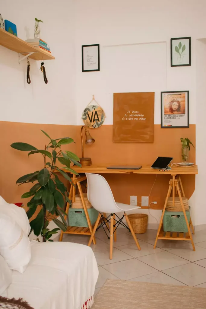 Framed prints, a macrame hanging, and a hand-painted quote board, wall decor idea for a terracotta home office