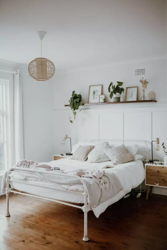 Framed art and dried florals on a floating shelf as natural over the bed wall decor