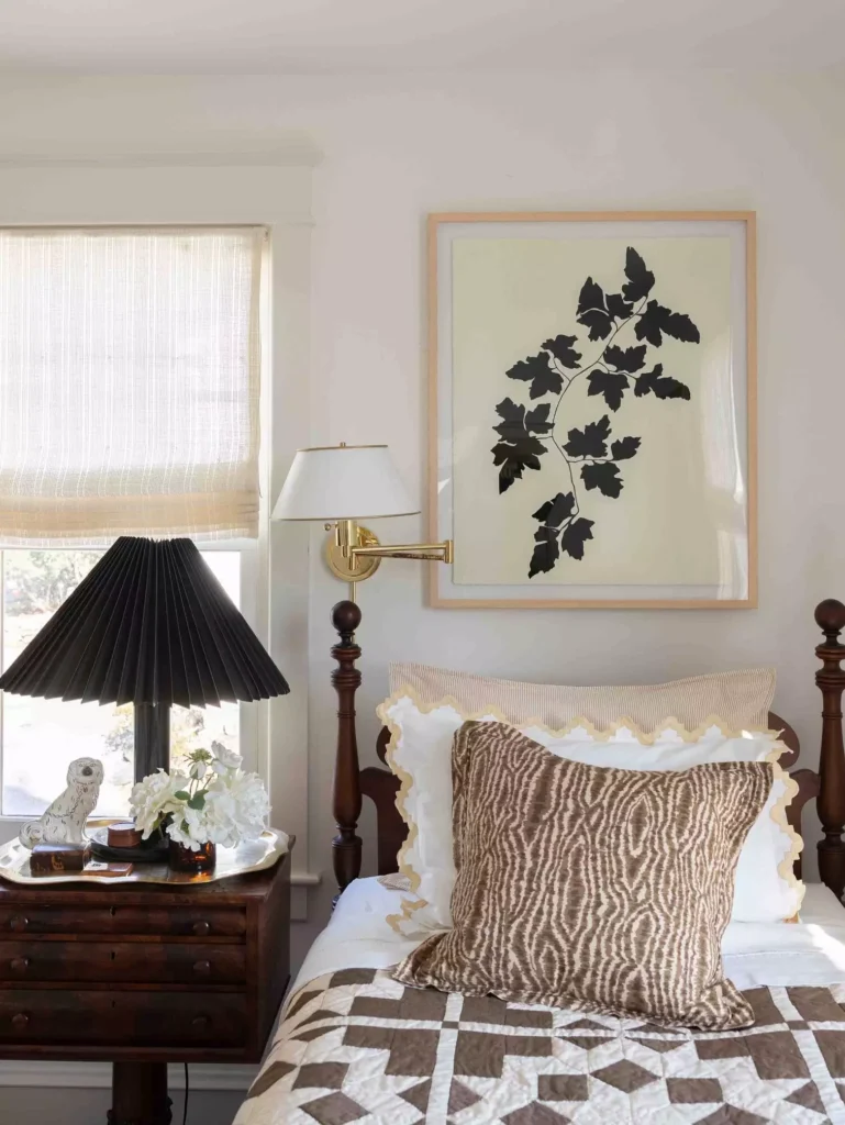 Framed black botanical leaf print as vintage inspired over the bed wall decor above a wood bed