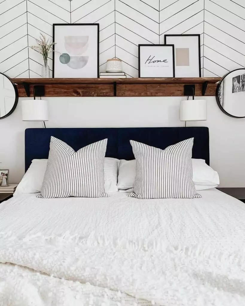 Gallery shelf with framed art and mirrors as over the bed wall decor above a navy tufted headboard