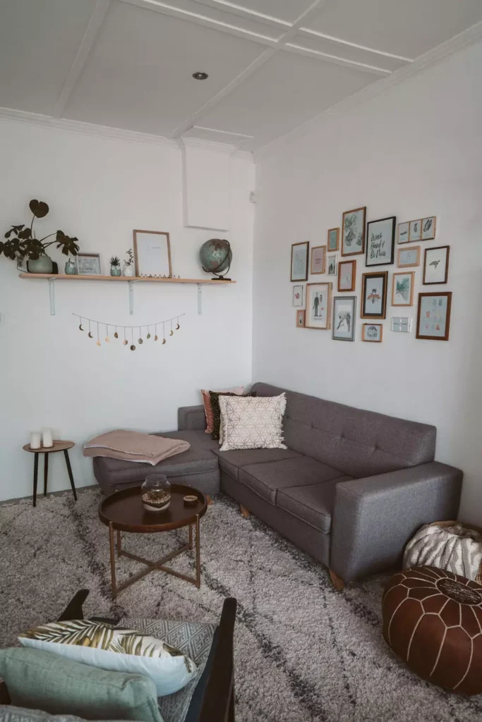 Gallery wall Corner Wall Decor with frames and long floating shelf above grey L-shaped sofa corner