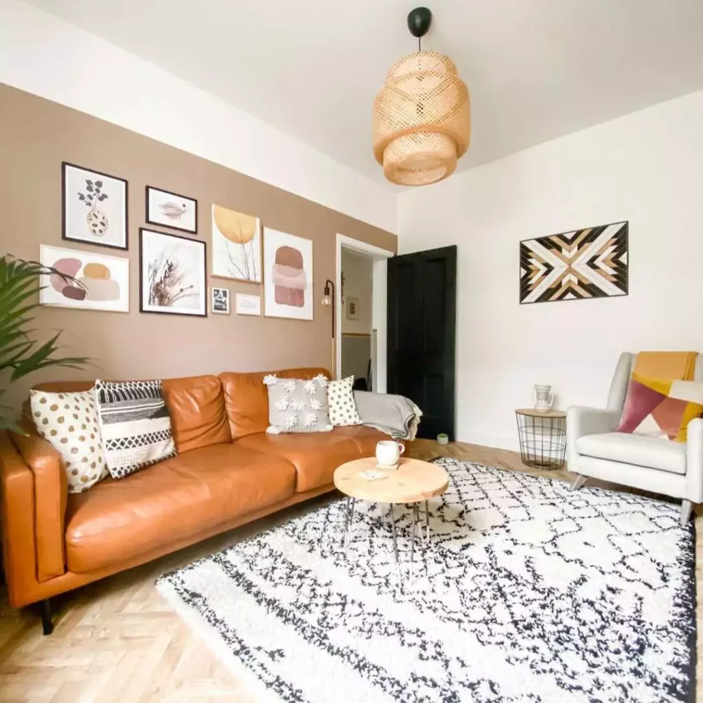 Gallery wall and geometric wood wall art in living room with tan leather sofa