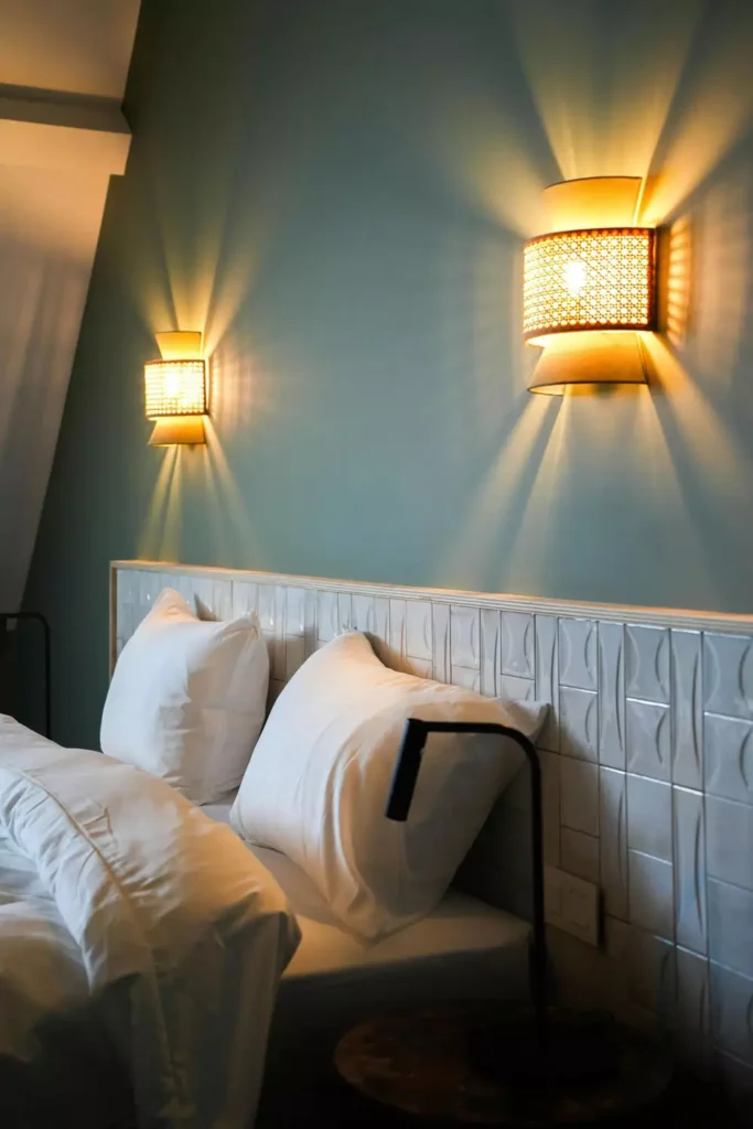 Glowing rattan wall sconces flanking a tiled headboard for moody over the bed wall decor