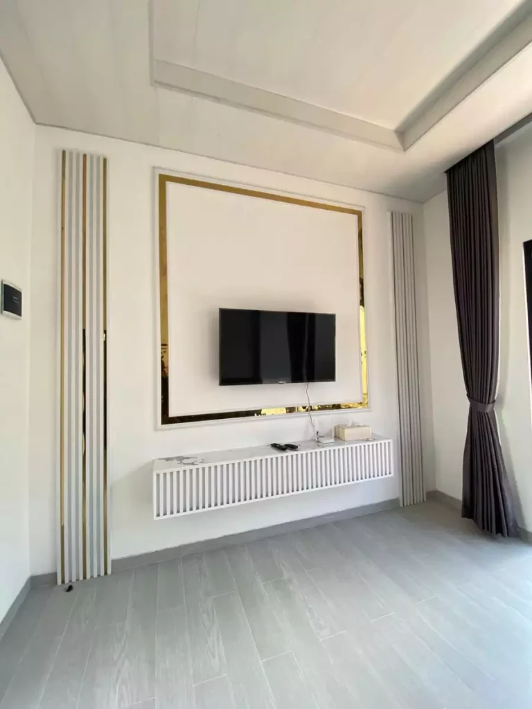 Gold Framed TV Wall With Fluted Side Panels And Radiator Style Console