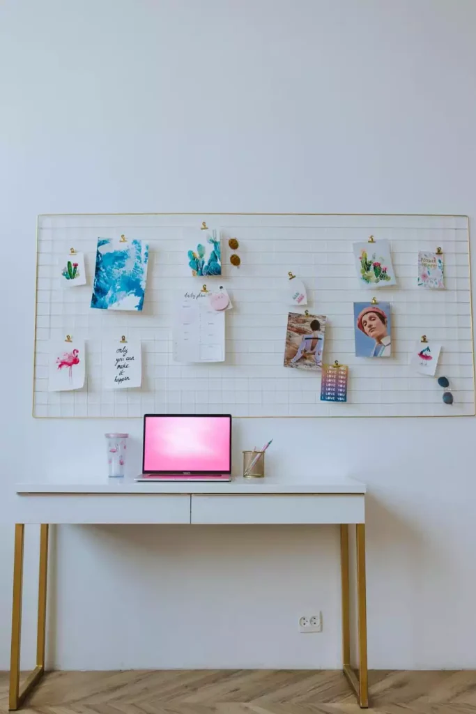 Gold Wire Grid Memo Board Dorm Wall Decor With Clipped Art Prints Above A White Desk