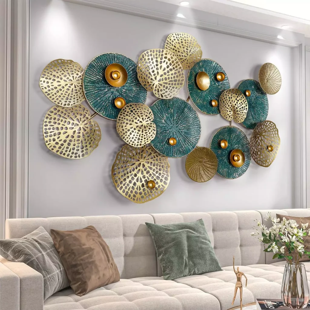 Gold and teal metal disc wall sculpture above beige tufted sofa