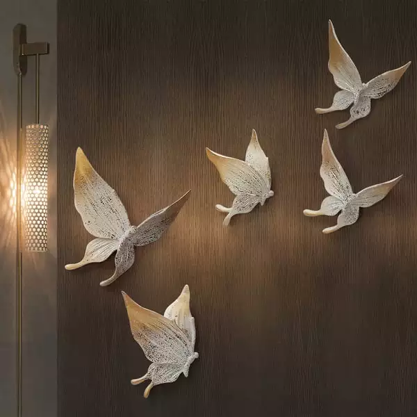 Gold textured Butterfly Wall trio glowing beside a woven floor lamp