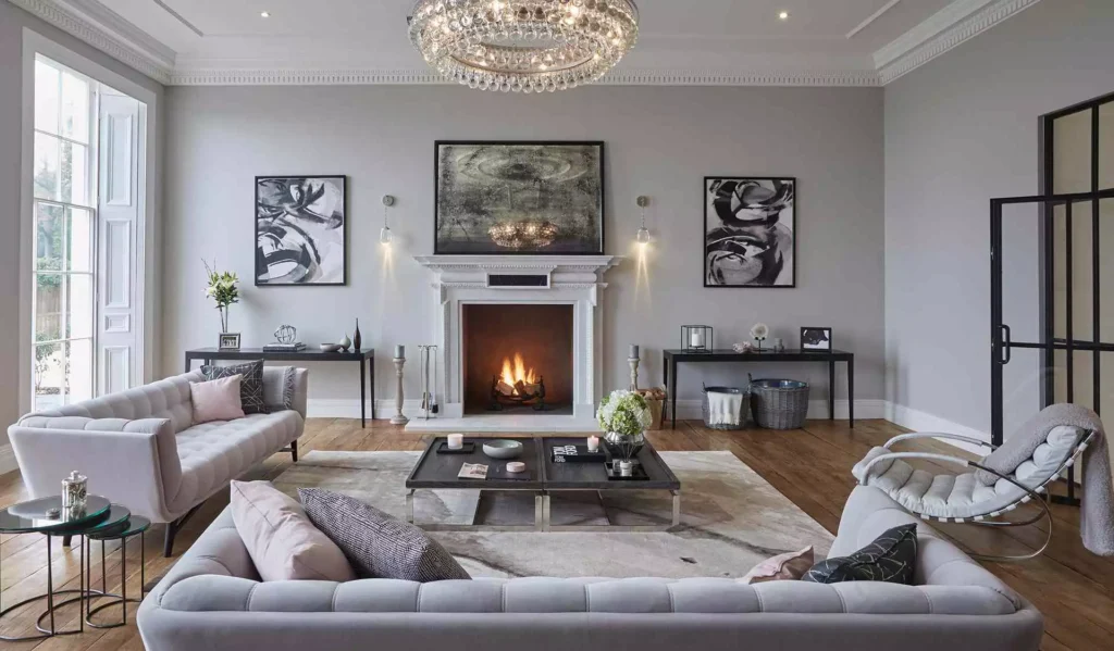 Grand grey living room decor idea with crystal chandelier, fireplace and abstract art pair