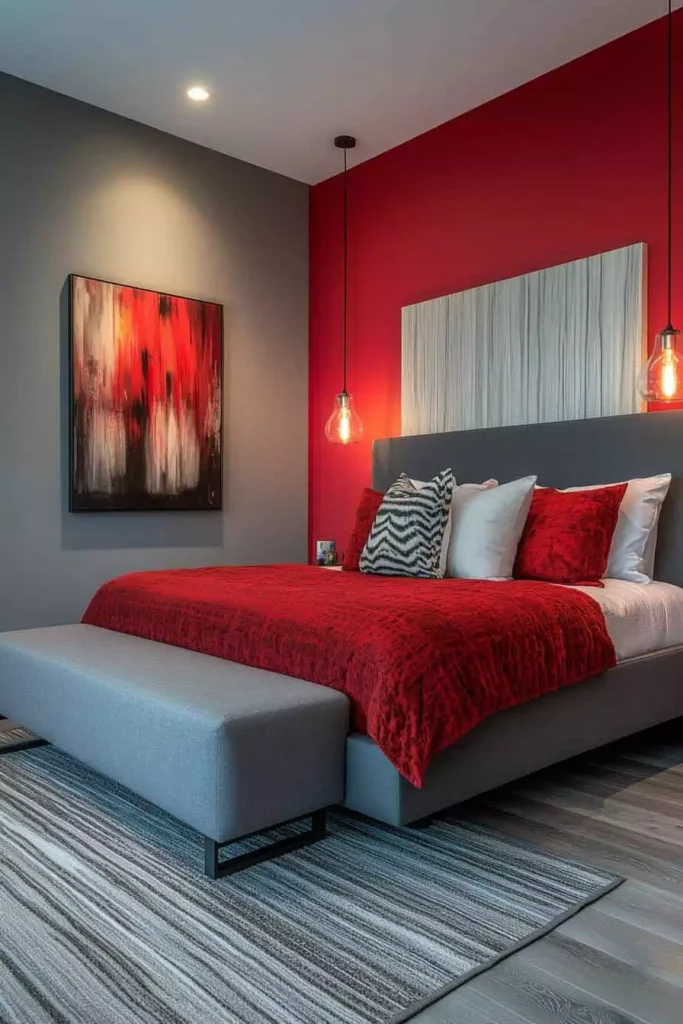 Grey bedroom wall beside a bold red accent wall with matching red bedding