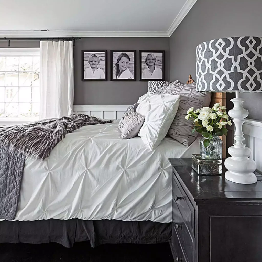 Grey bedroom wall decor idea with white pintuck bedding and family portrait gallery
