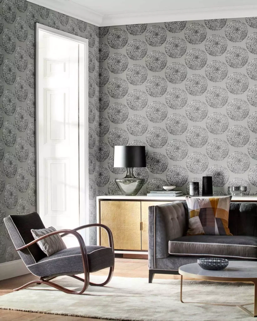 Grey floral wallpaper accent wall behind velvet armchair and sofa in a living room decor idea