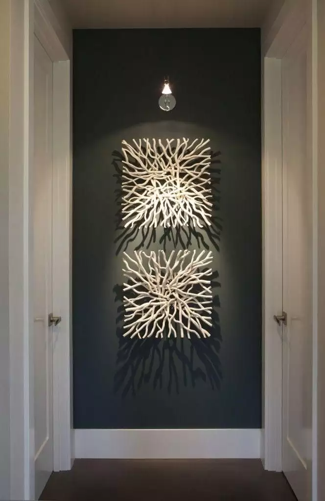 Hallway wall alcove featuring sculptural coral branch art under a single sconce